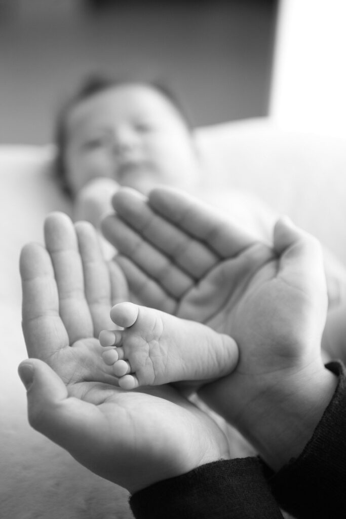 parent qui tien doucement le pied de son bébé